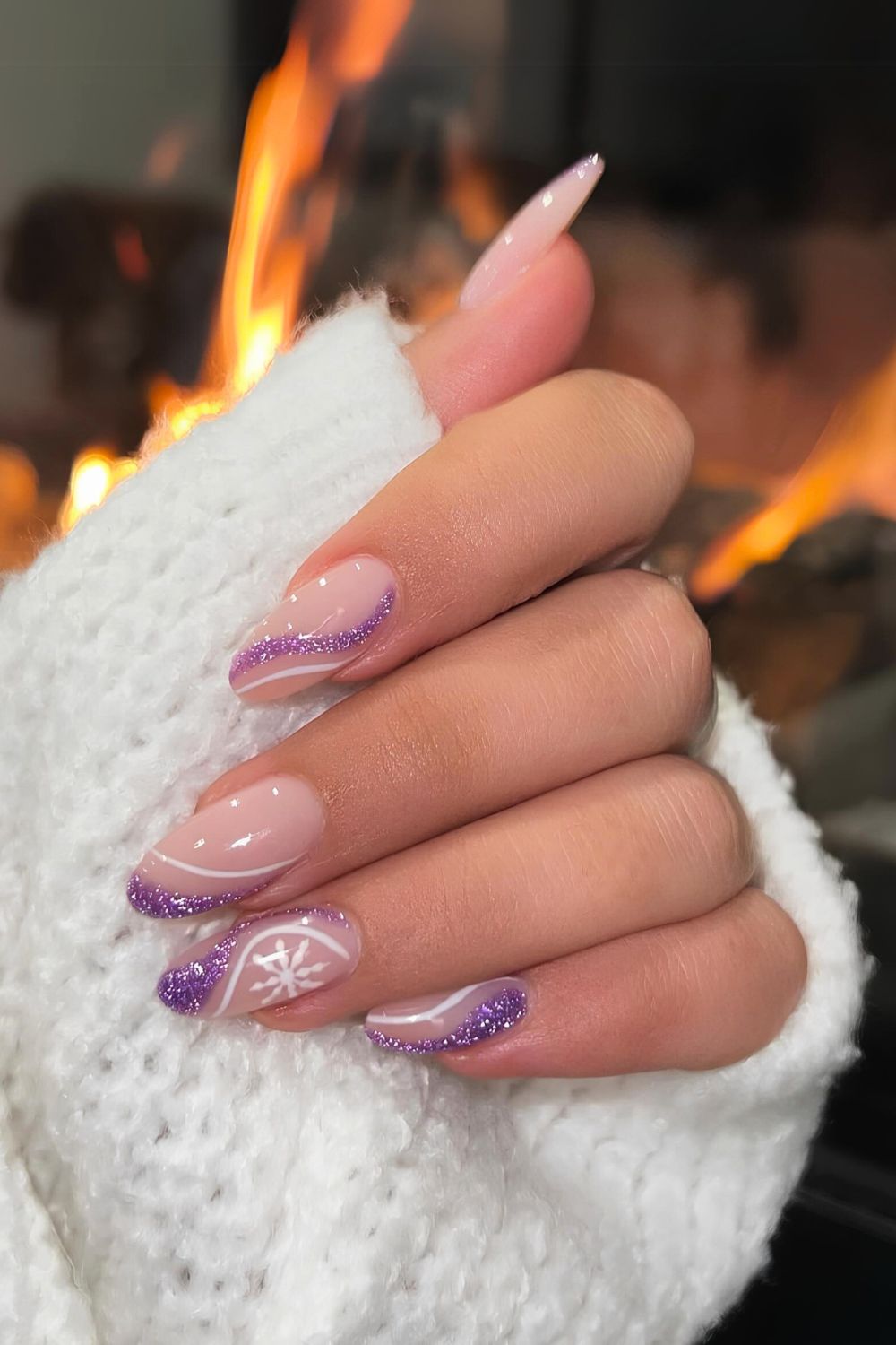 Nude nails with glittery purple swirls and snowflakes