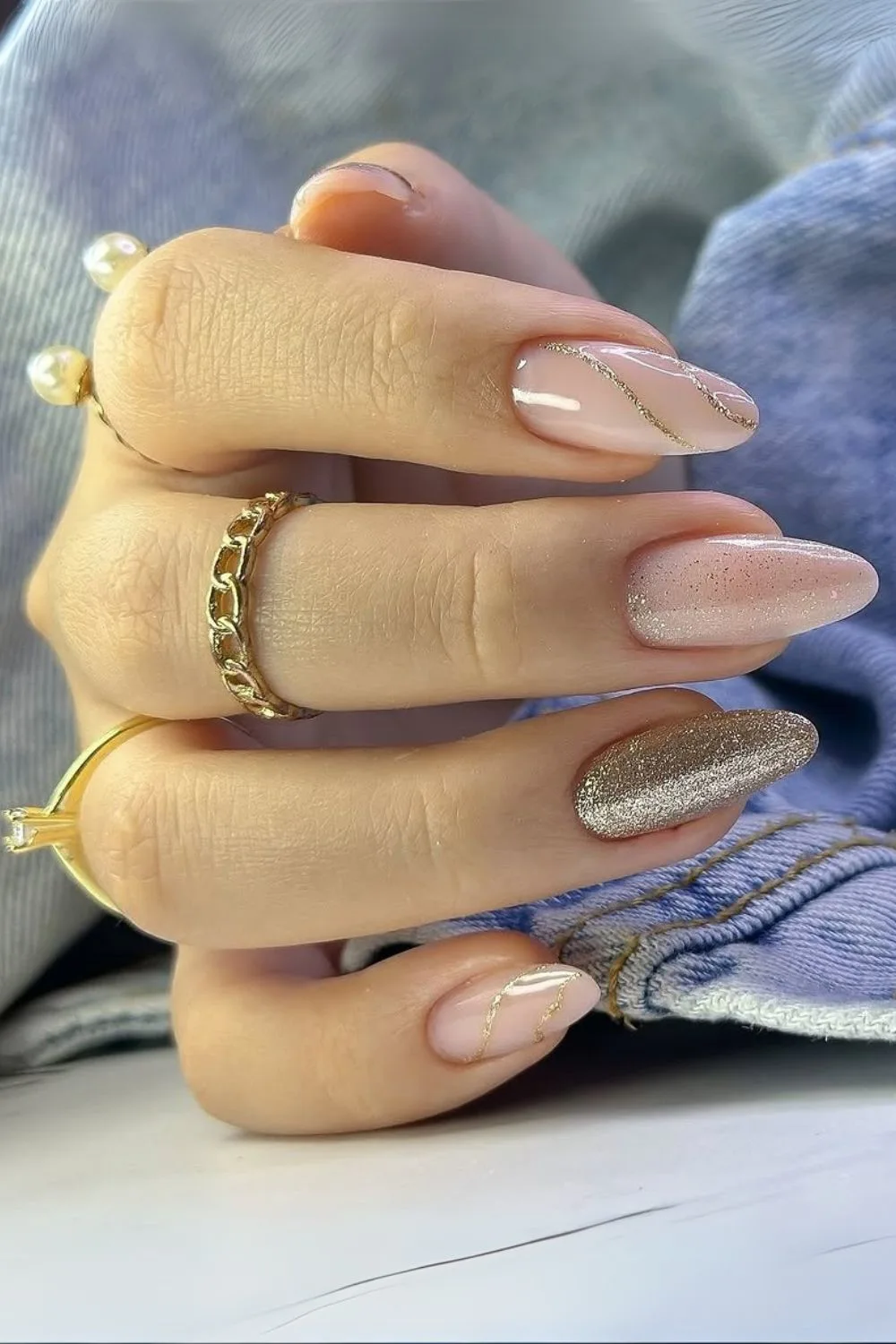 Nude nails with gold glitter accents