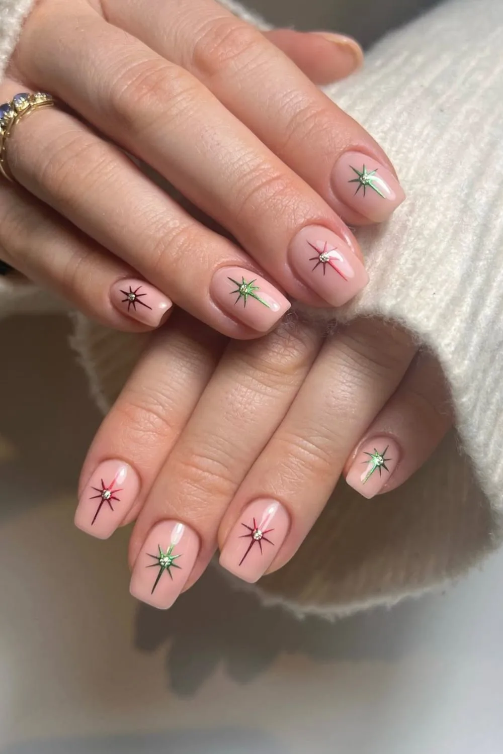 Nude nails with red and green chrome stars