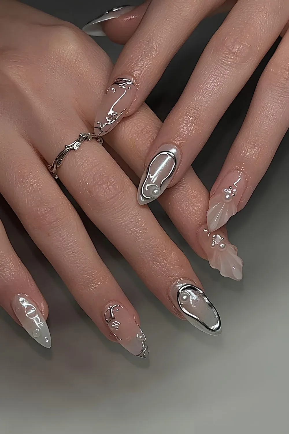 Nude nails with silver chrome and pearl accents