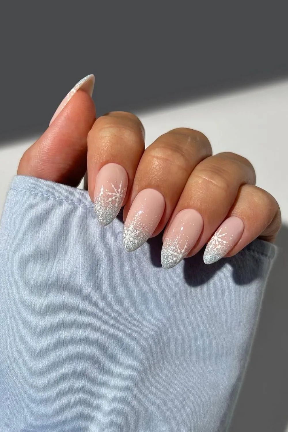 Nude nails with silver glitter tips and snowflakes