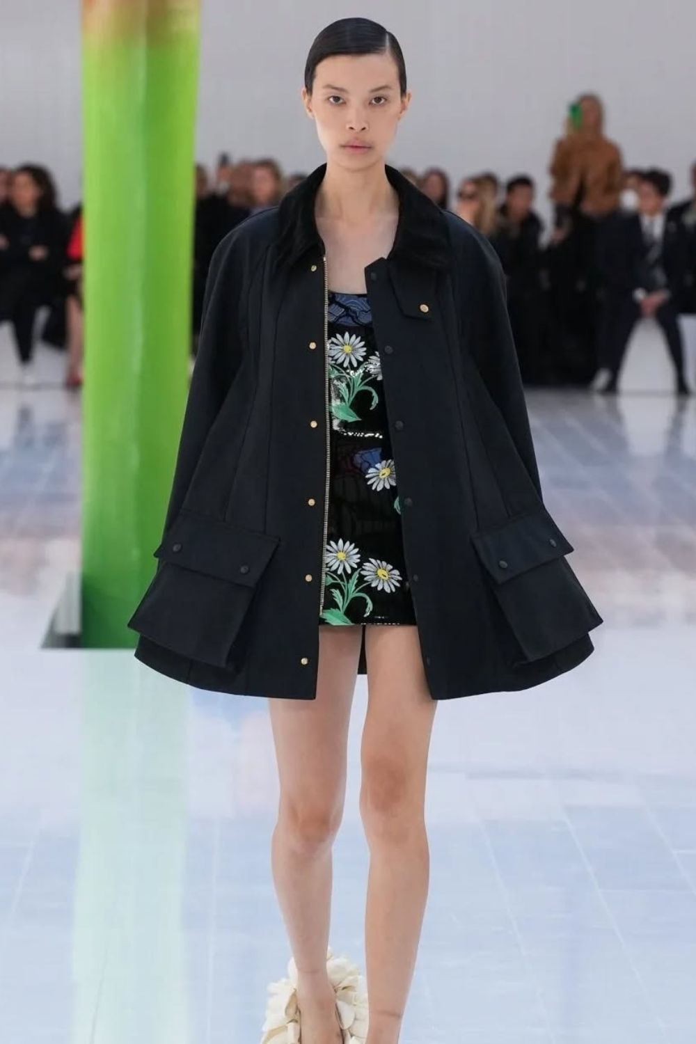 Oversized black barn jacket with classic large utility pockets paired with a daisy embroidered mini dress