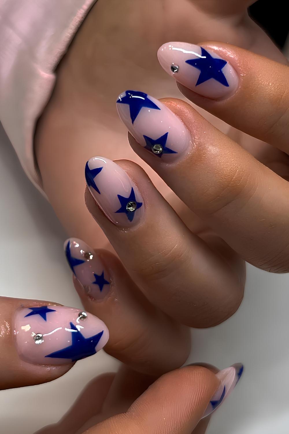 Pink nails with dark blue stars and rhinestones