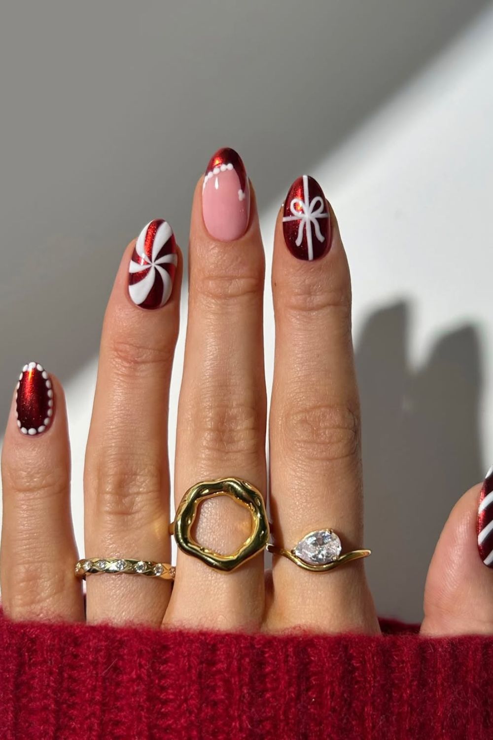 Red and white chrome nails with candy cane peppermint accent and bow