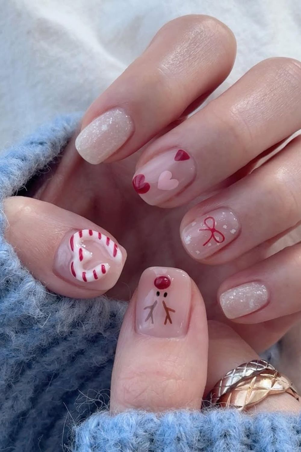 Red and white nails with 3D candy cane heart and bow, reindeer and snowy accents