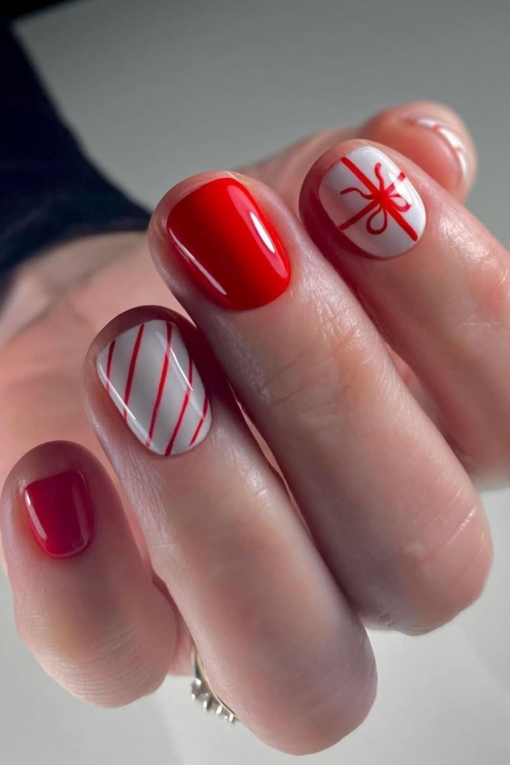 Red and white short nails with bow and stripes accents