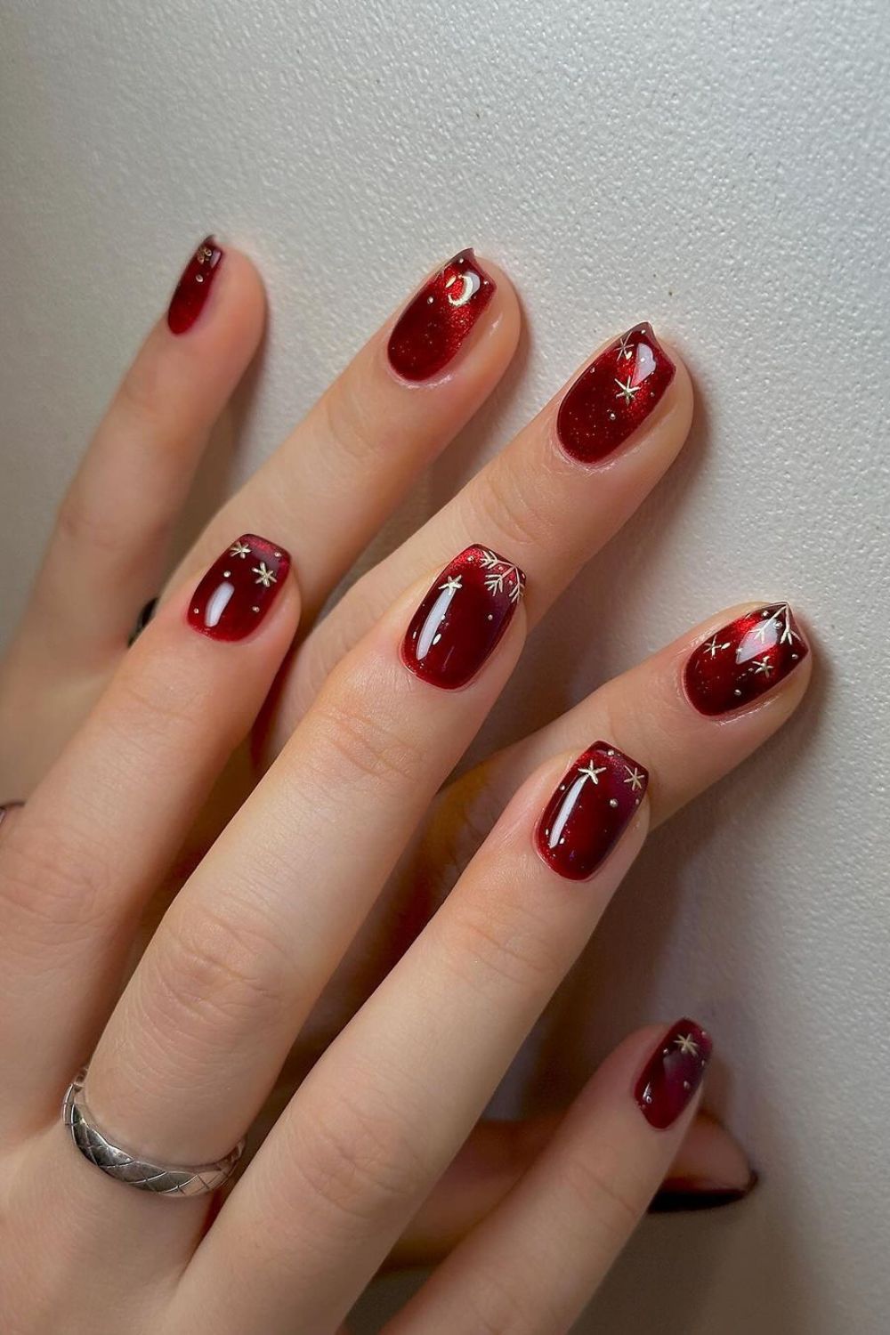 Red cat-eye nails with white snowflakes