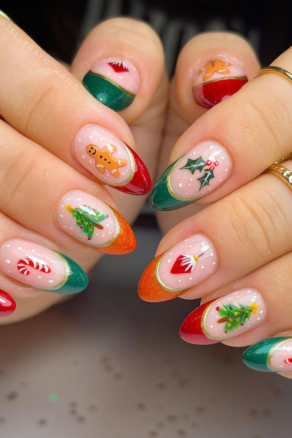 Red, green and orange French tip nails with gingerbread man, Christmas tree, holly berry and candy cane accents