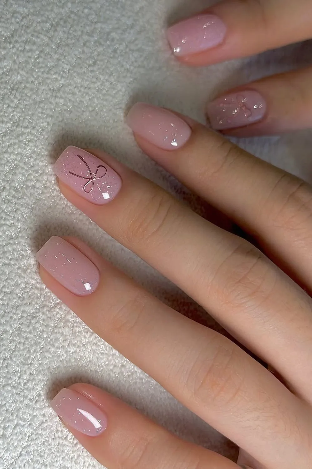 Shimmery pink mani with coquette bows