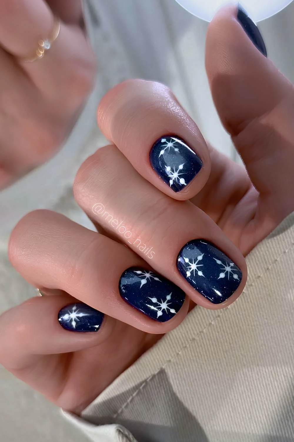 Short navy blue nails with snowflake art