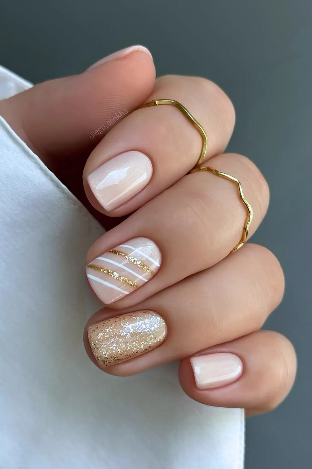 Short neutral mani with gold Christmas-themed accents