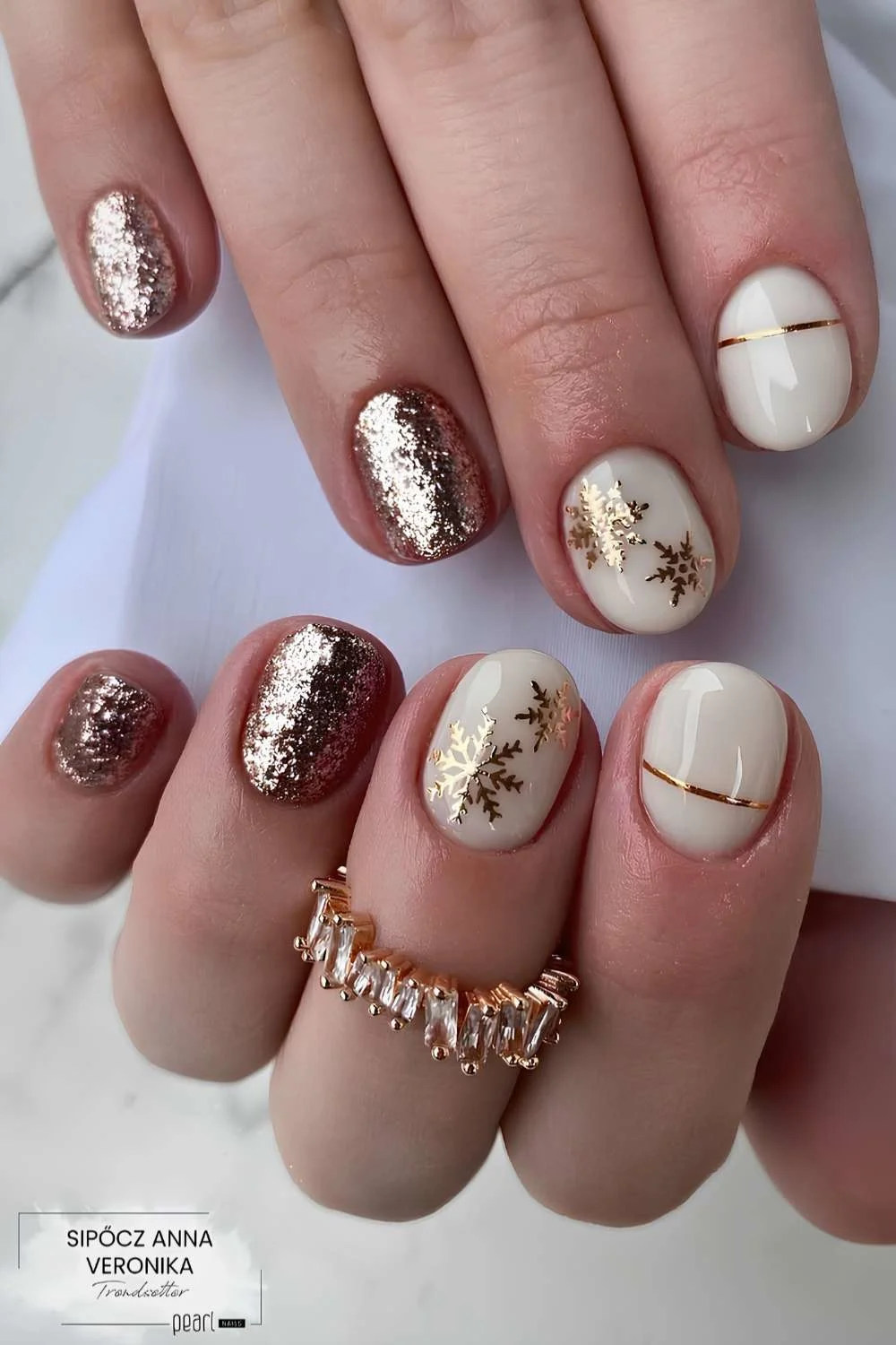 Short white and gold glitter nails with snowflakes
