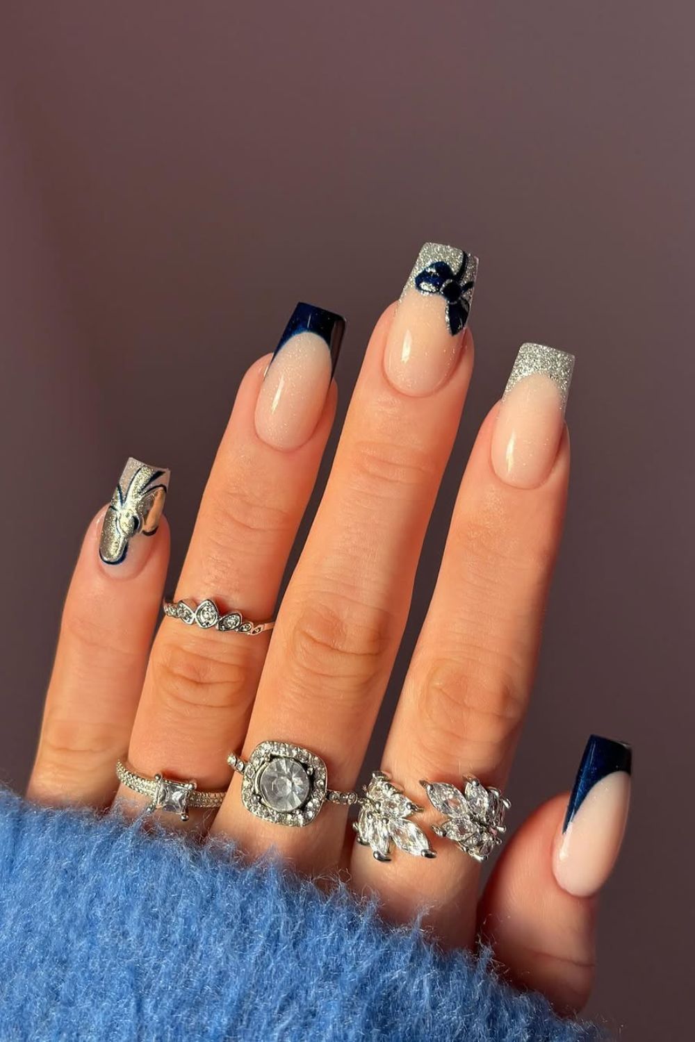 Silver and navy glitter French tip nails with navy bow accent