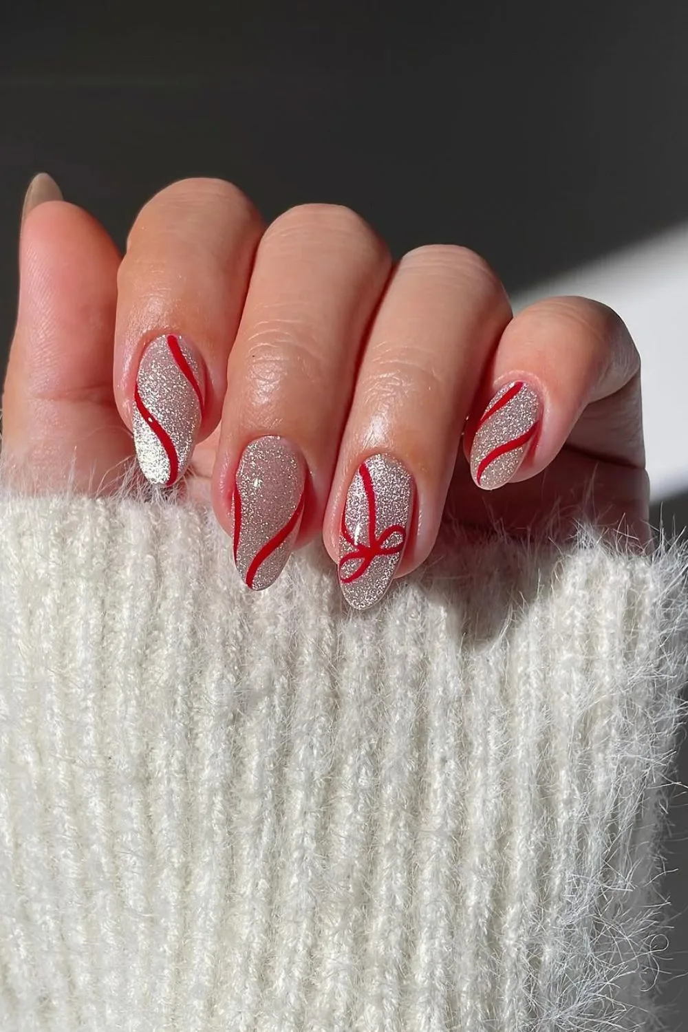 Silver cat eye effect nails with red bows and swirls 