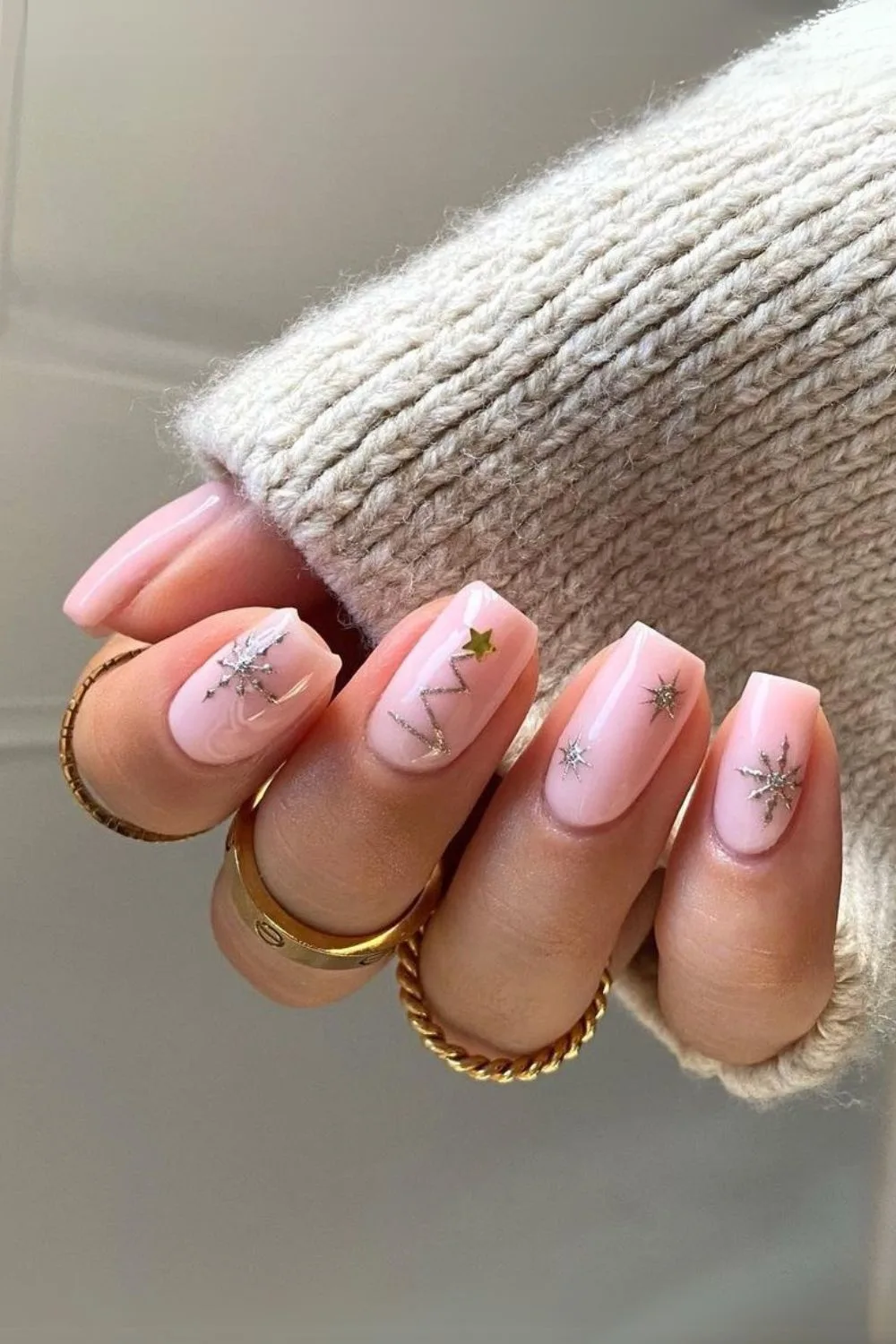 Soft pink nails with chrome snowflakes