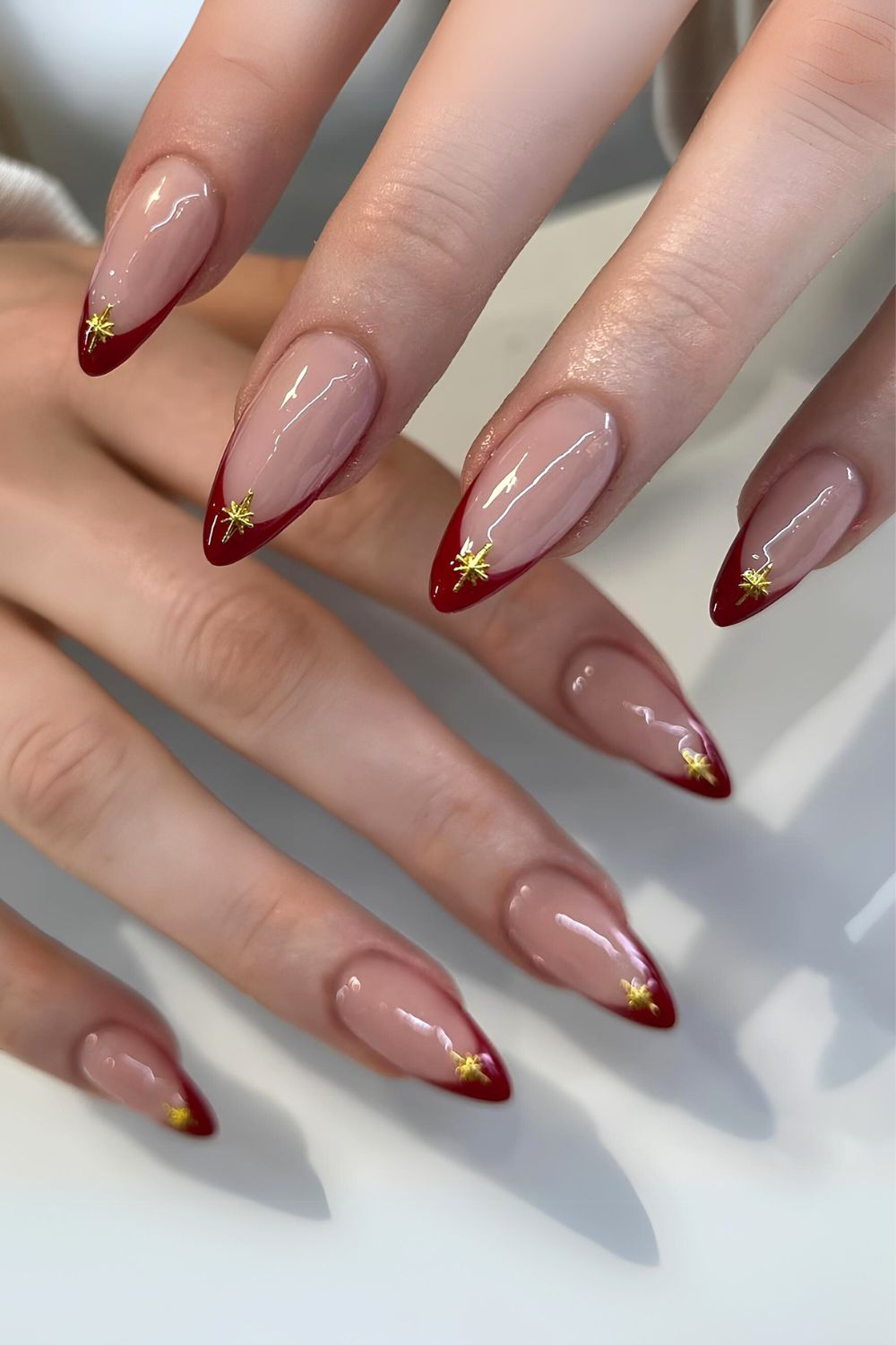 Sultry red French nails with chrome stars