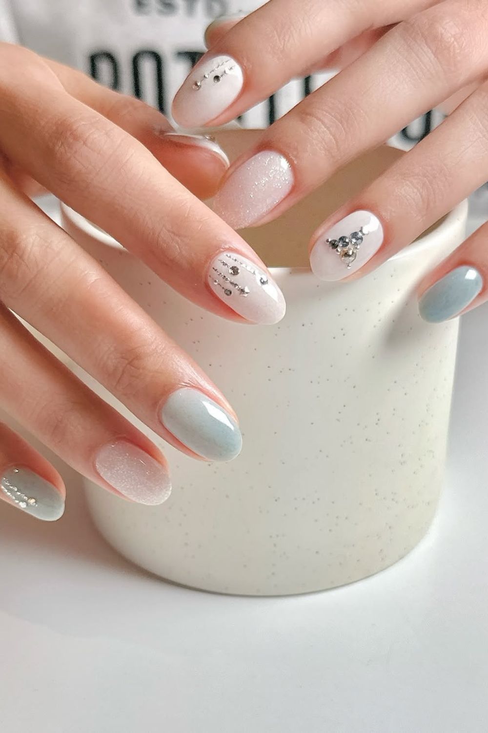 White and soft blue nails with rhinestone Christmas tree accent