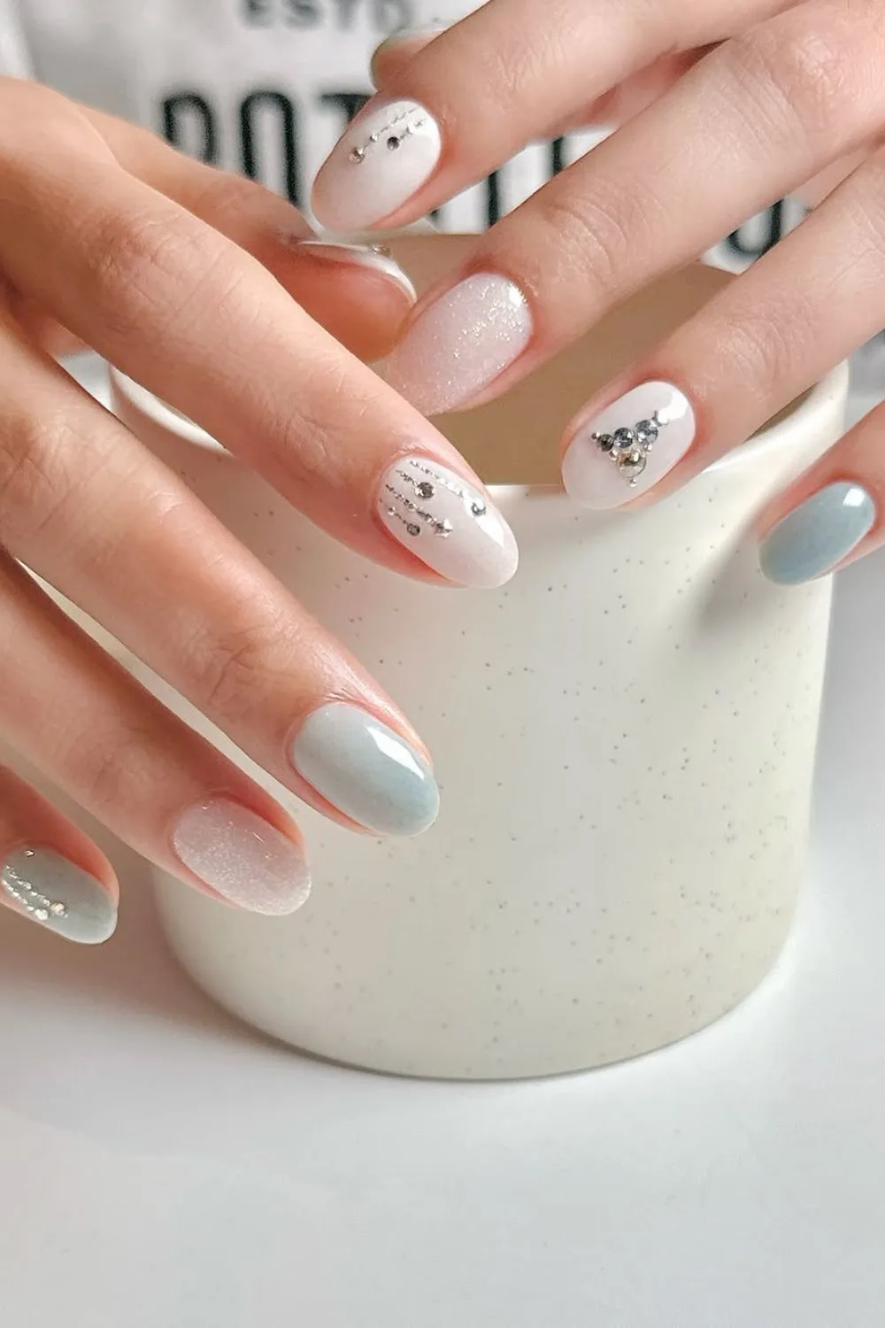 White and soft blue nails with rhinestone Christmas tree accent