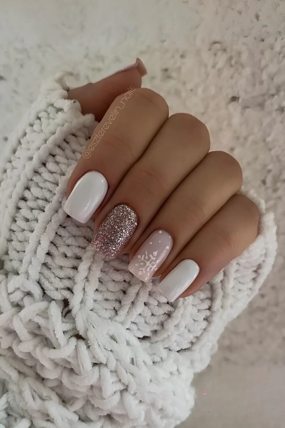 White nails with glitter and snowflake accents