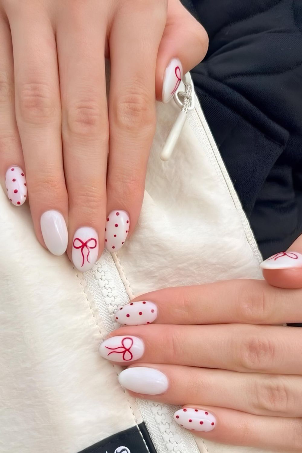 White nails with red bows and polka dots