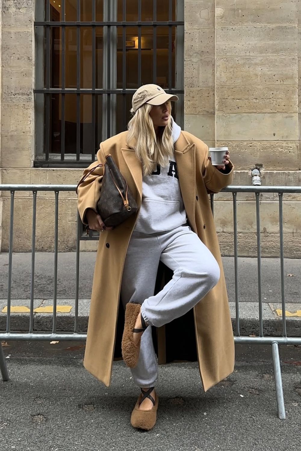 A woman wearing ballet sandals with sweatpants and coat on the street