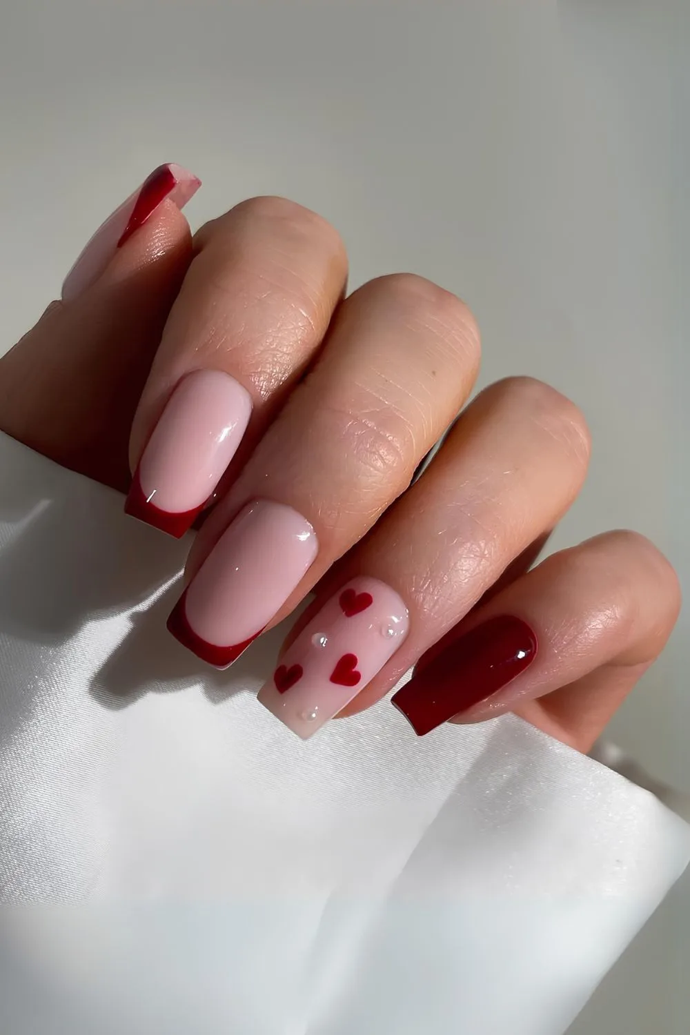 Burgundy French nails with hearts and pearls