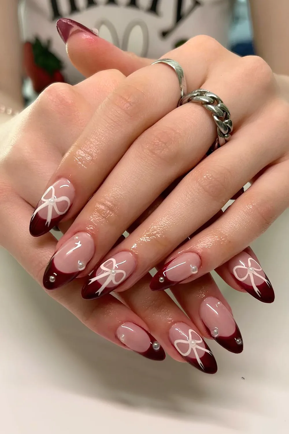 Burgundy French tip nails with bows and pearls