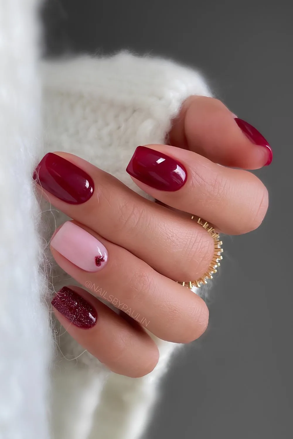 Dark red nails with glitter and heart accents