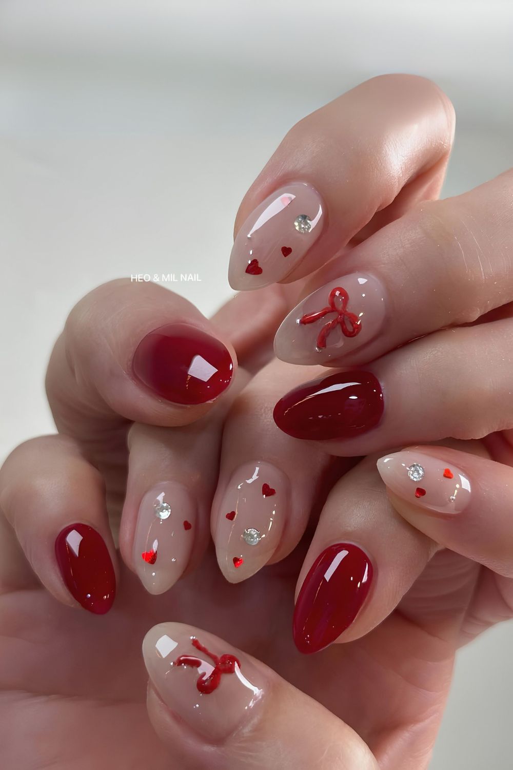 Dark red nails with hearts and bows