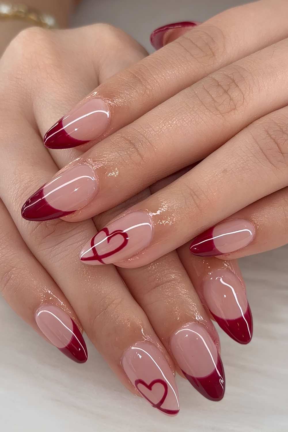 Deep red French mani with heart outlines