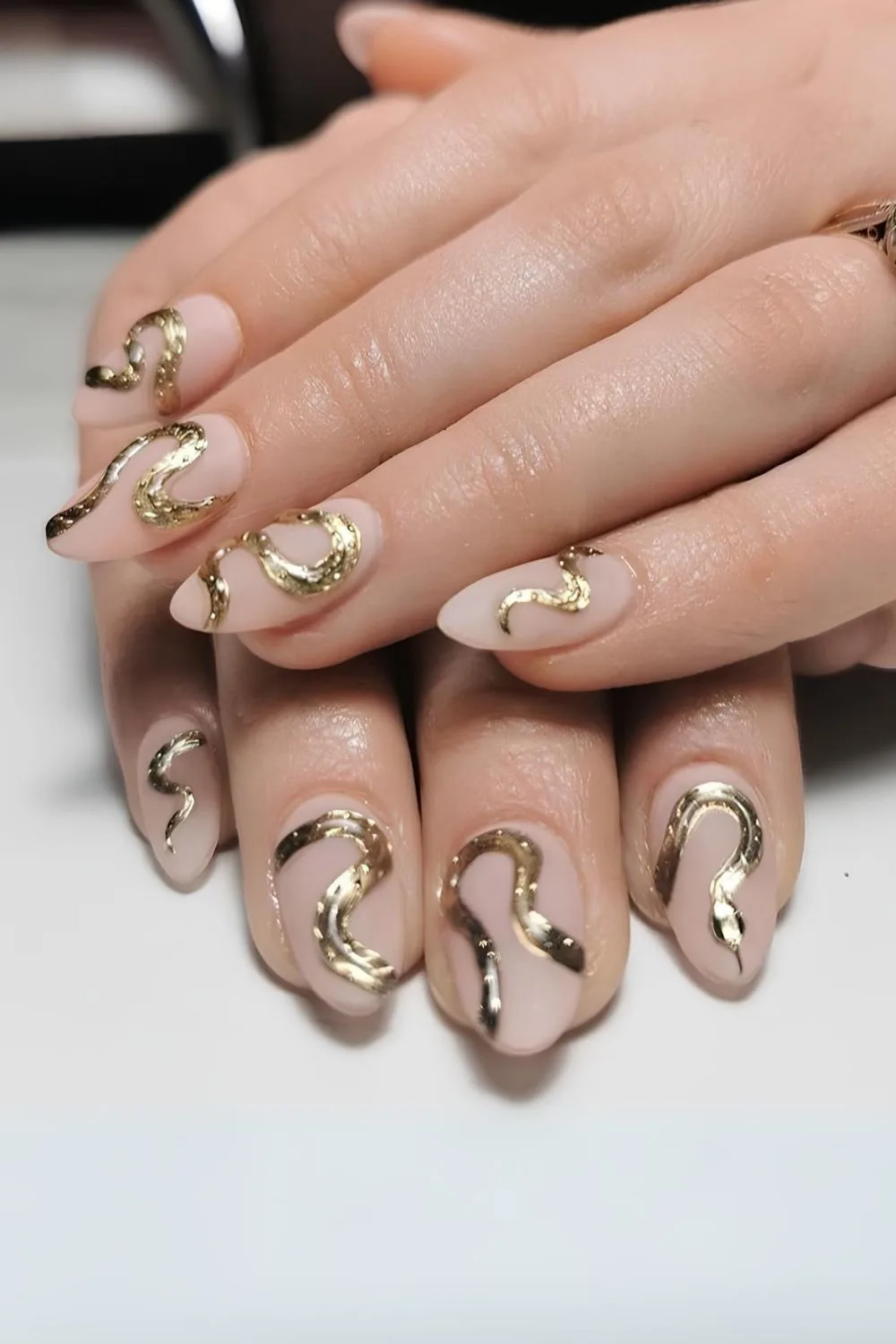 Golden snake design flowing across all nails