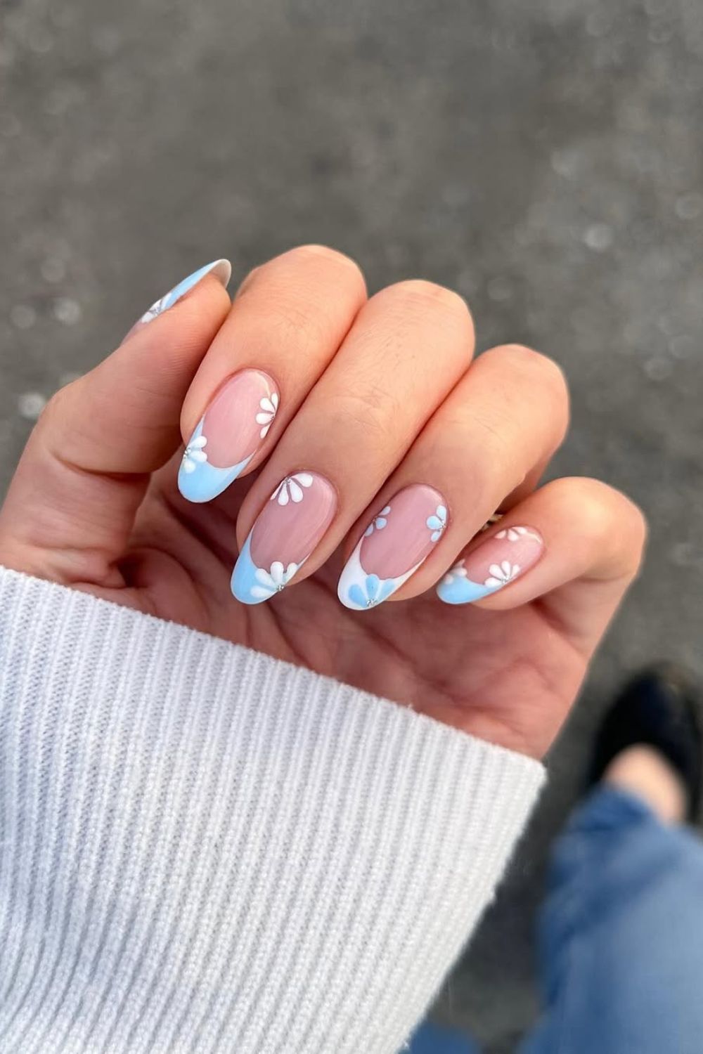 Light blue and white French tip nails with floral accents