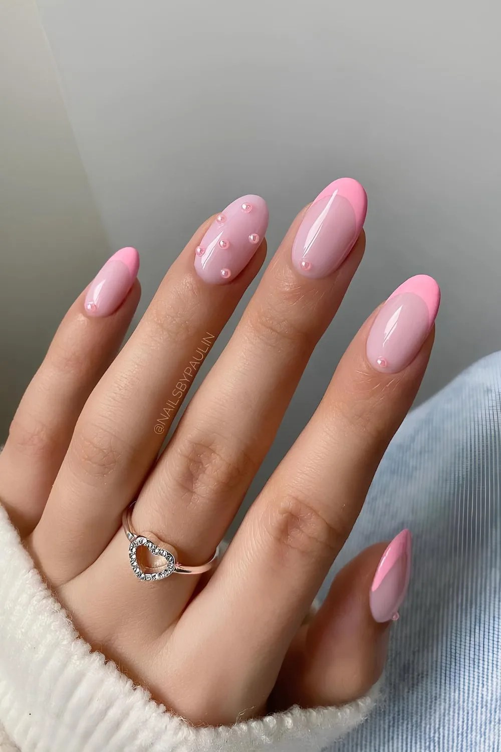 Light pink French tip nails with pearl accents