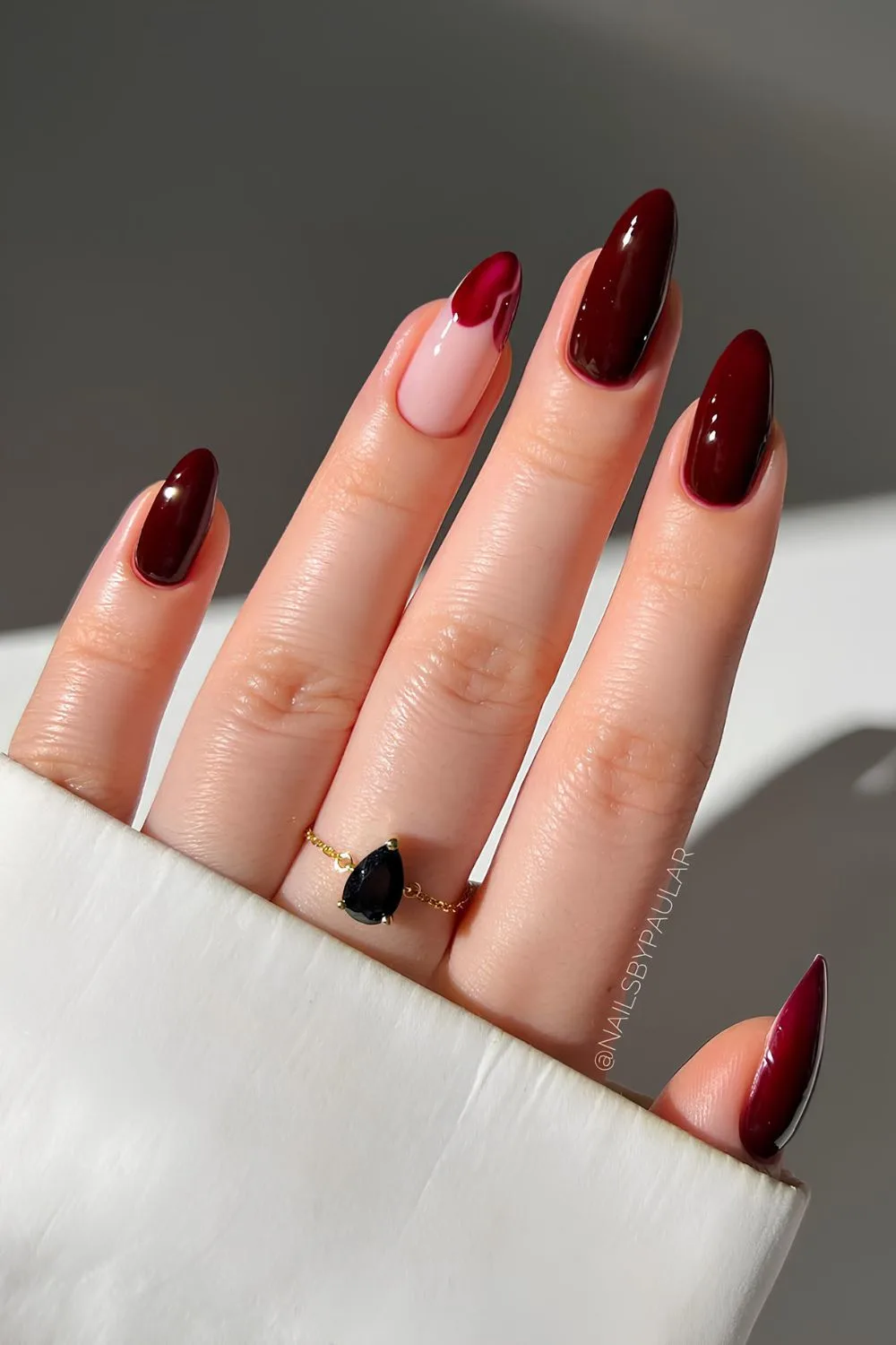 Maroon nails with broken heart tip accent