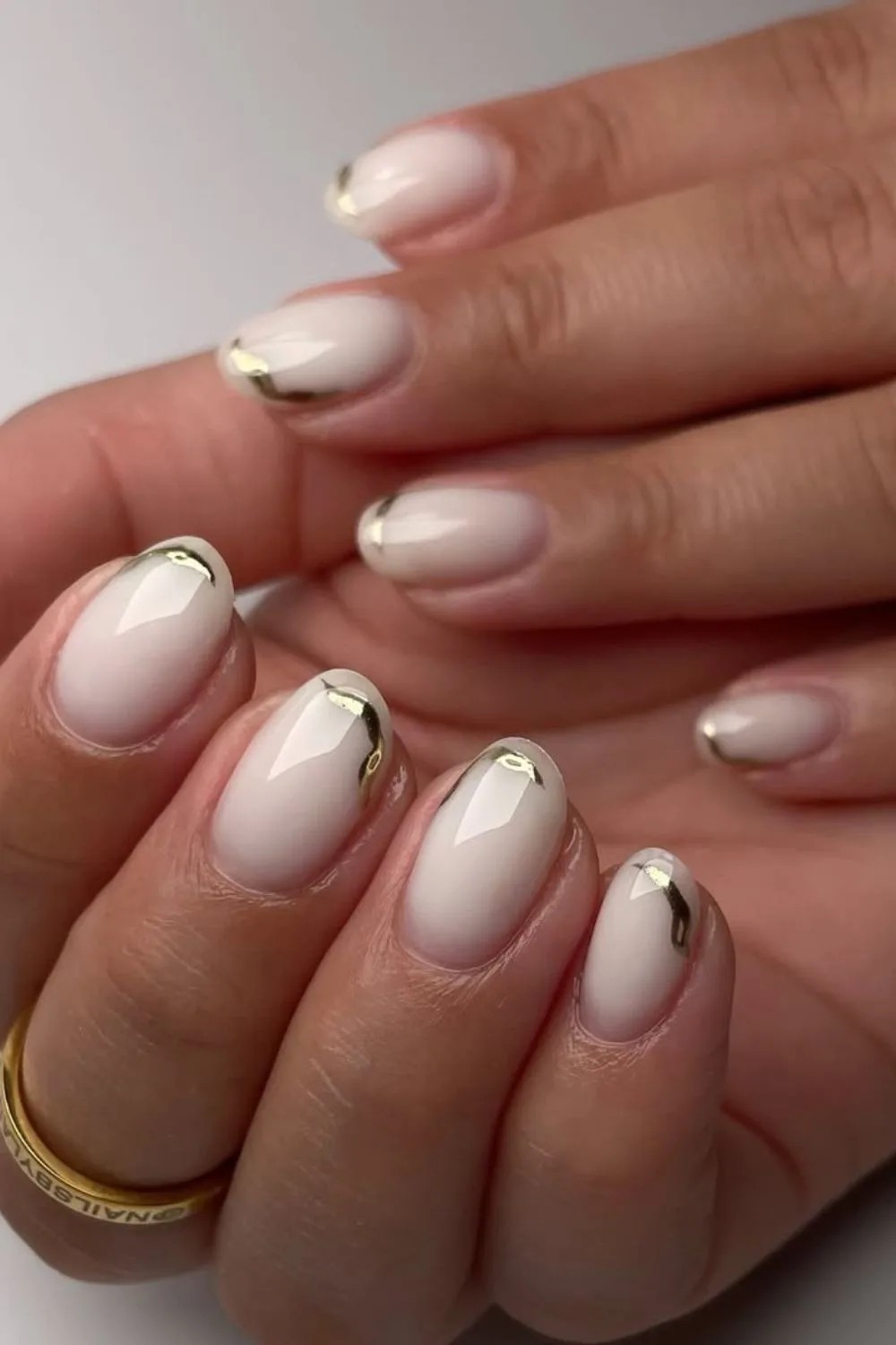 Milky nails with chrome accents in gold