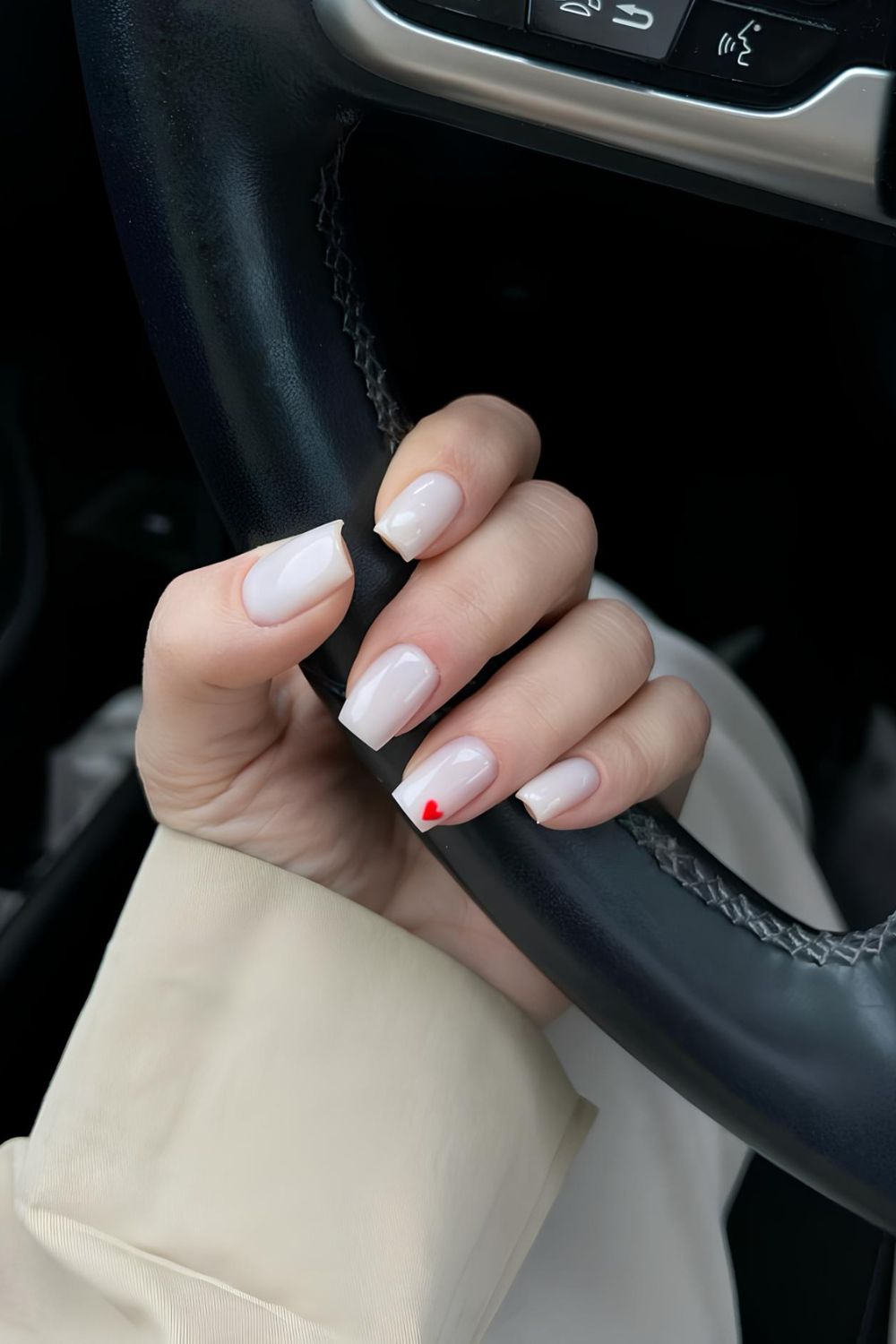 Milky white nails with single red heart accent