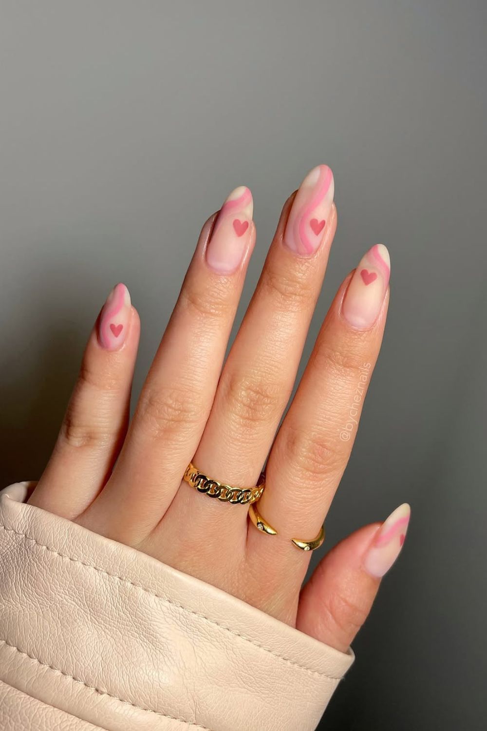 Neutral matte nails with pastel pink swirls and hearts