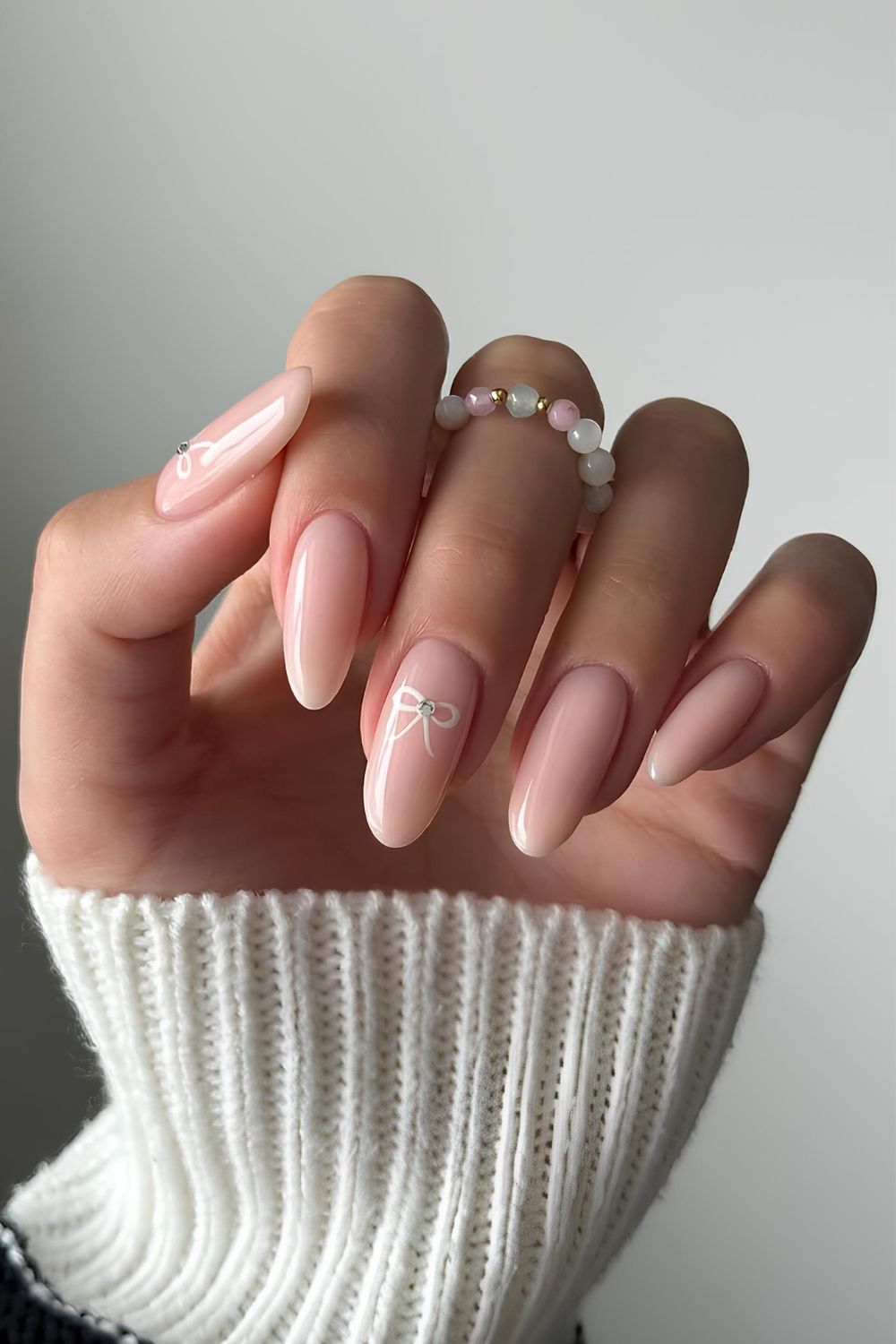 Neutral nails with white bow accents