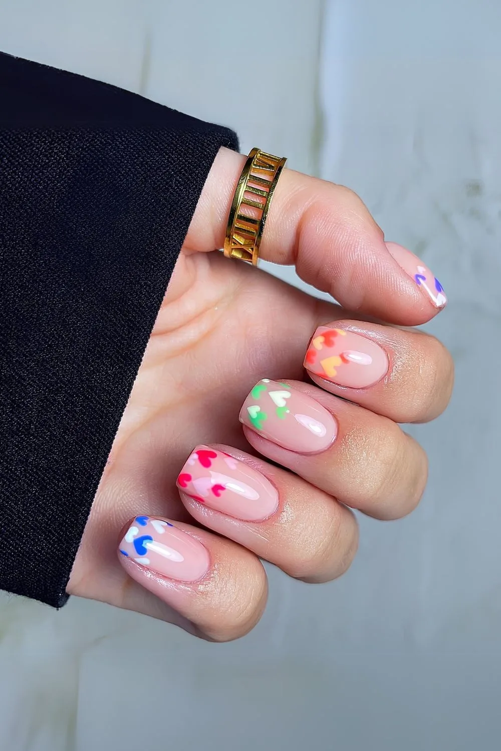 Nude nails with colorful heart accents