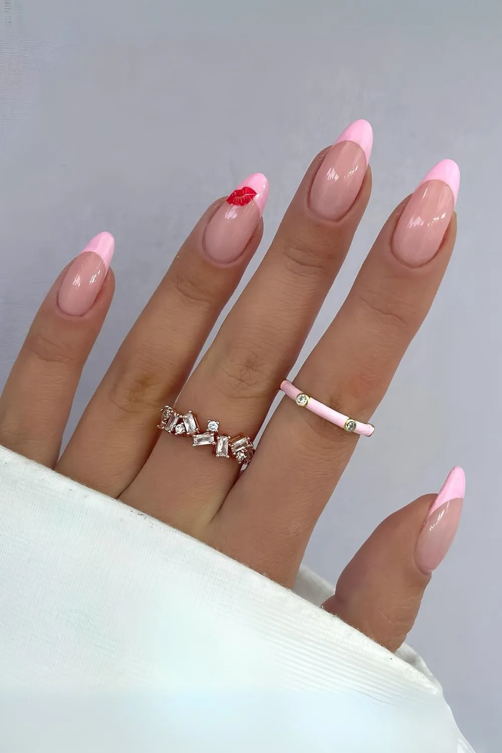 Pink french tips with a single kiss design