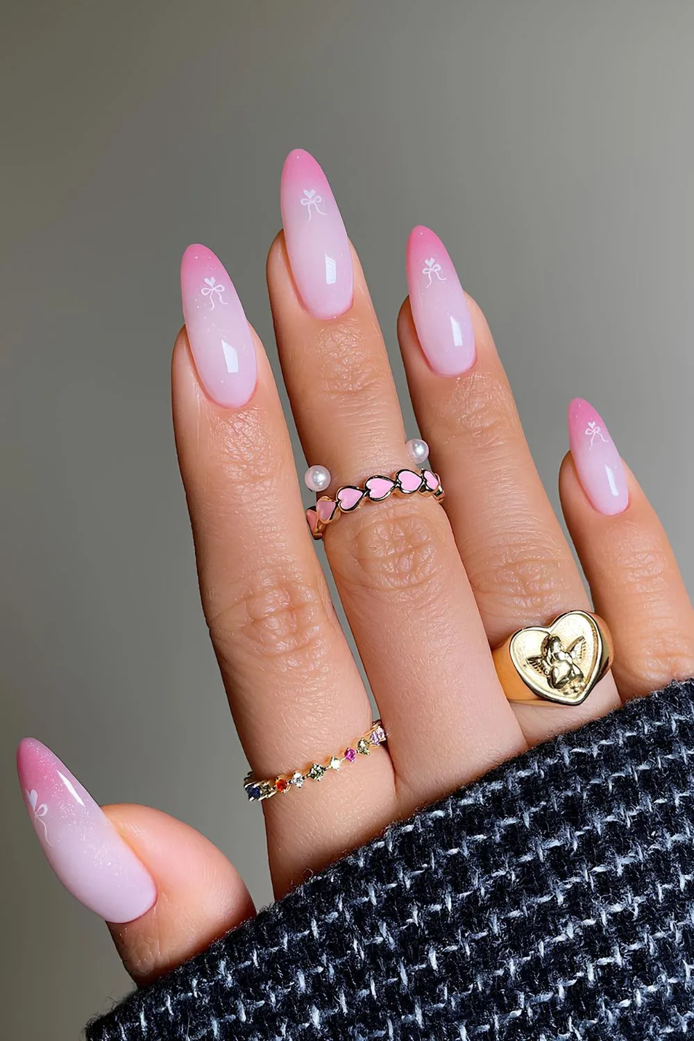 Pink ombre French tip nails with tiny bows and hearts