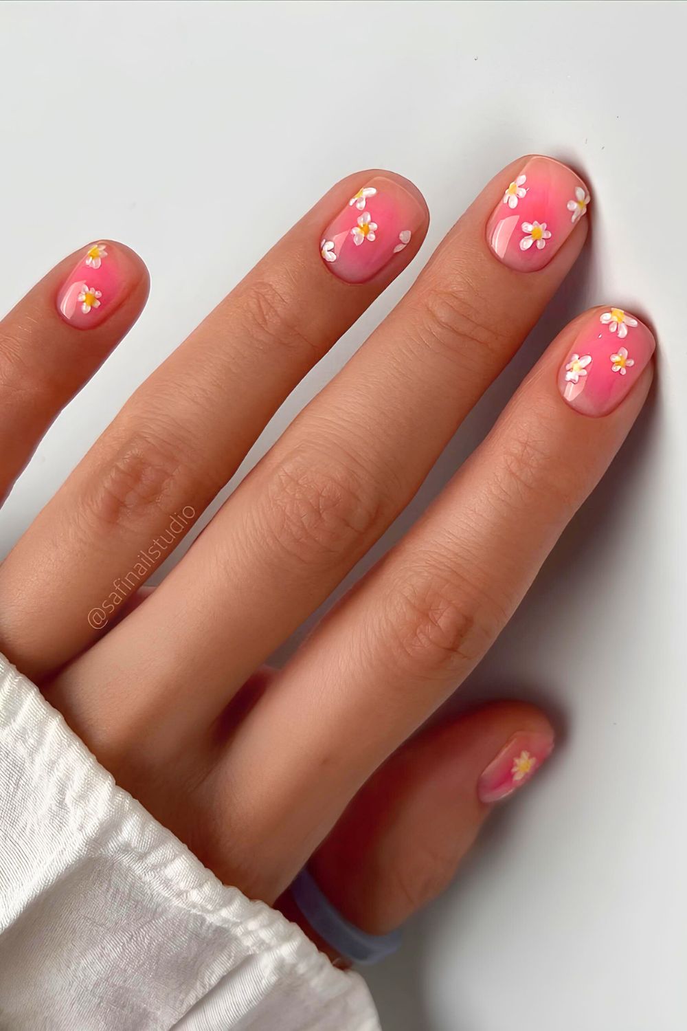 Pink short nails with blush effect and floral accents