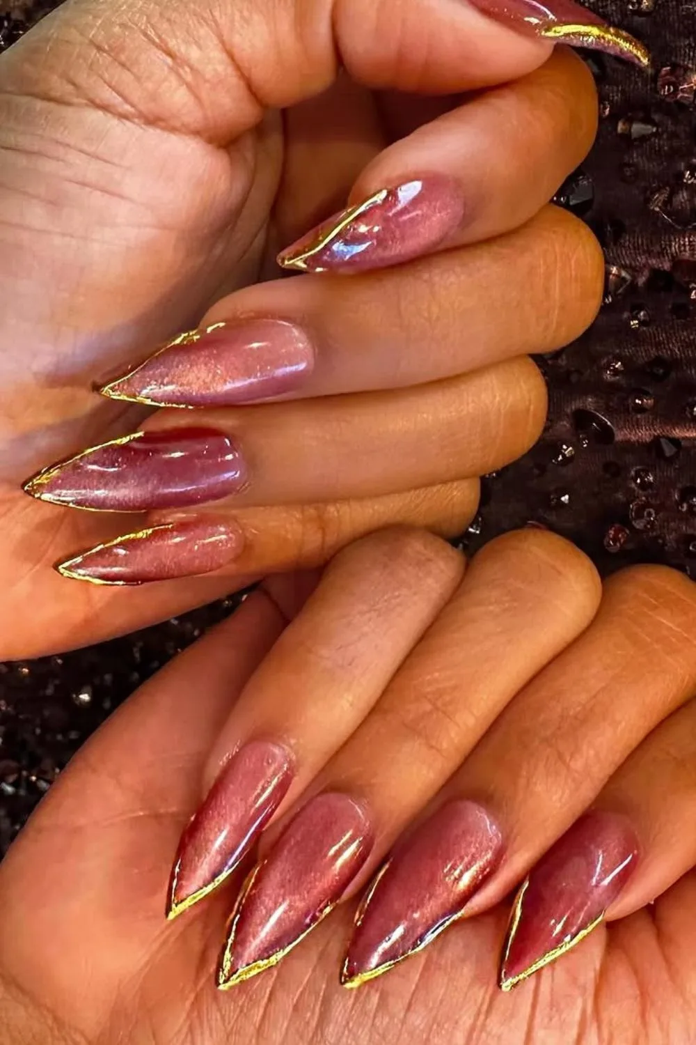 Pointed shimmery pink nails with gold chrome tips