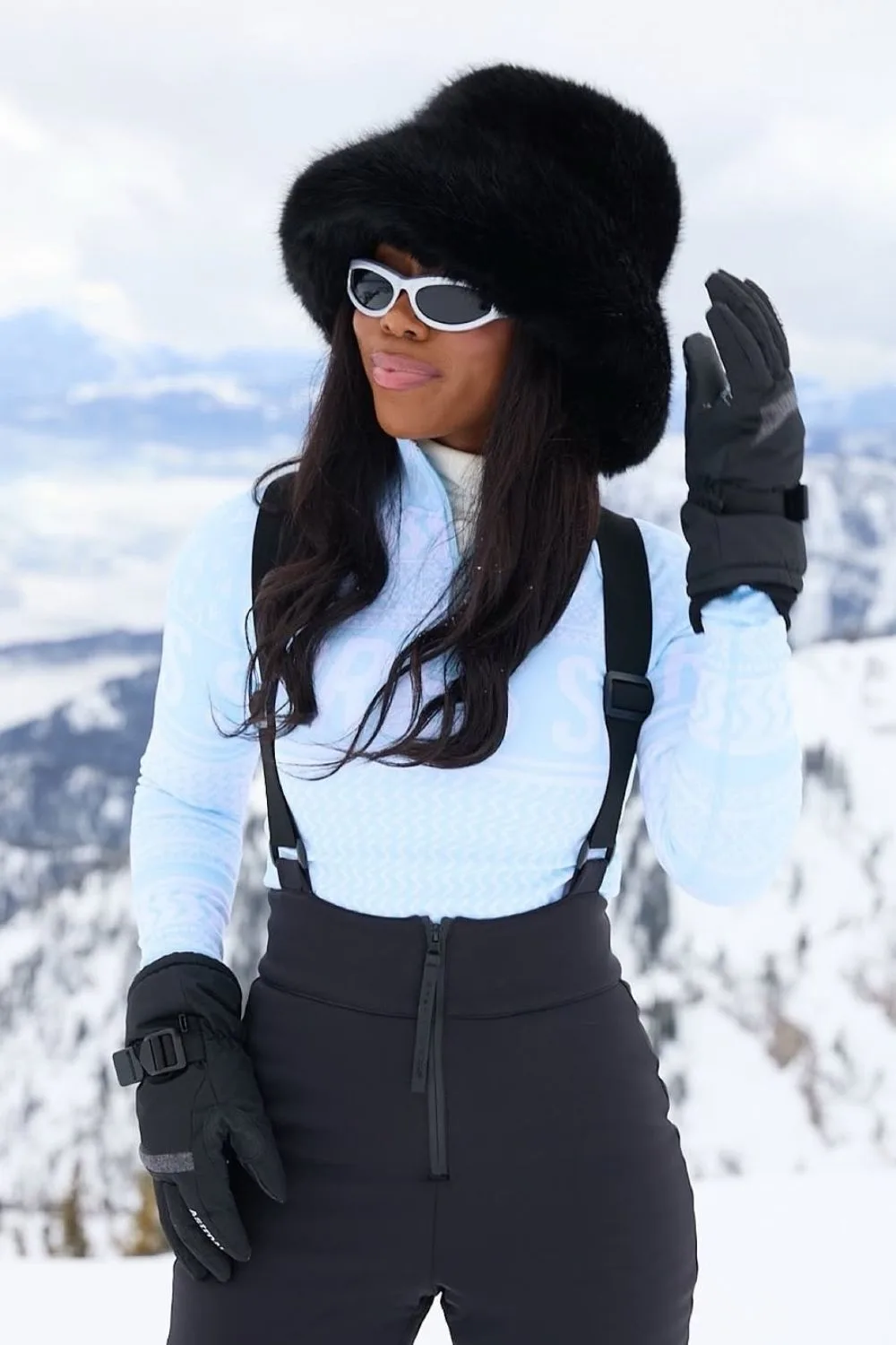 Powder blue snow shirt with black fur hat and ski trousers