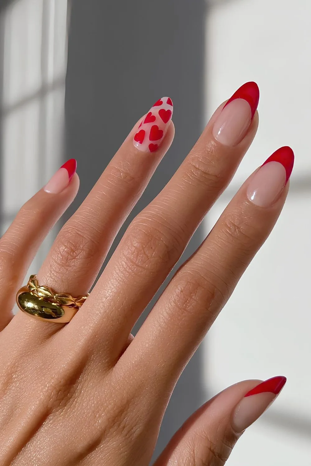 Red French mani with hearts on accent nail