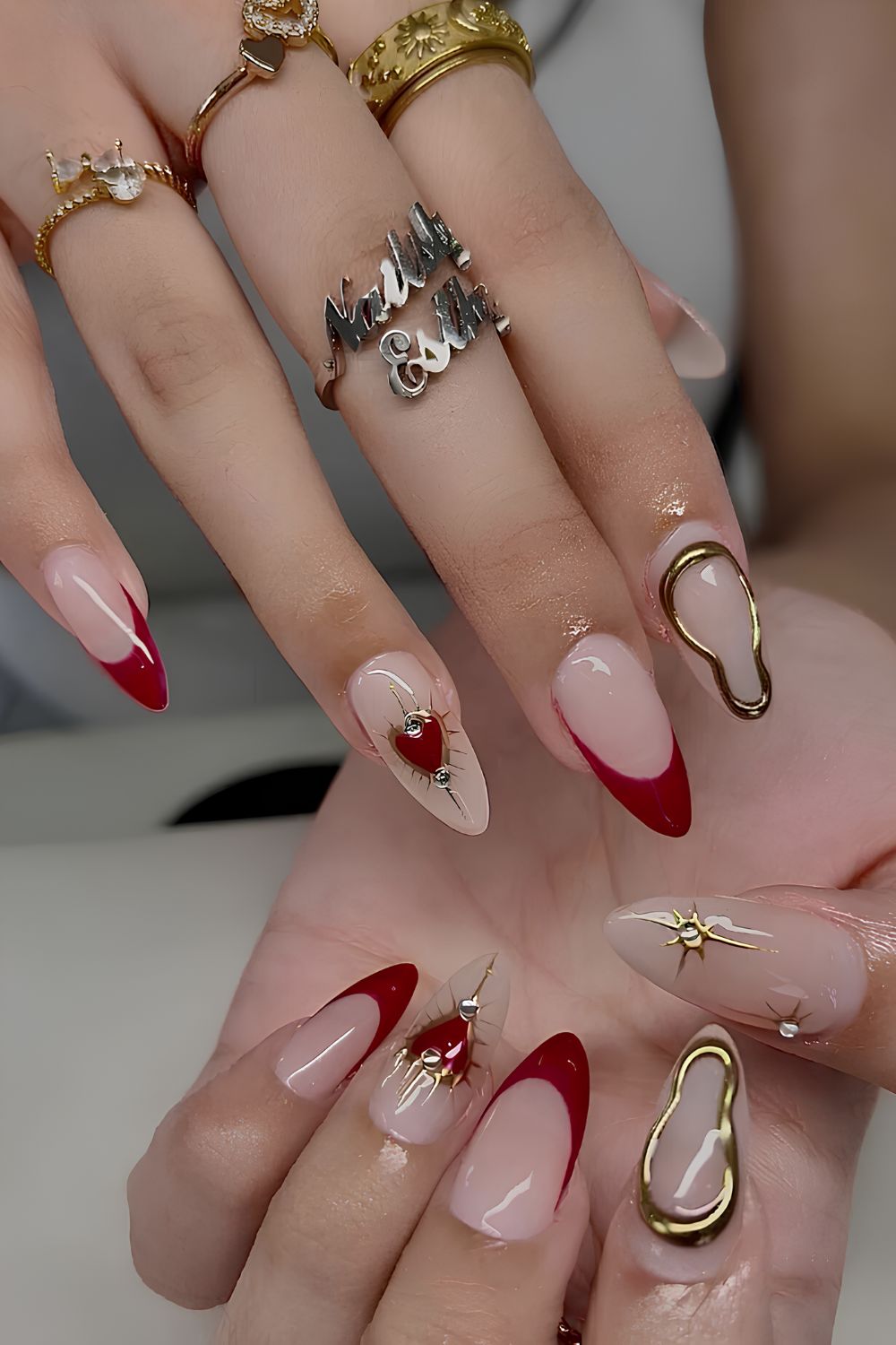 Red French nails with hearts and gold chrome accents