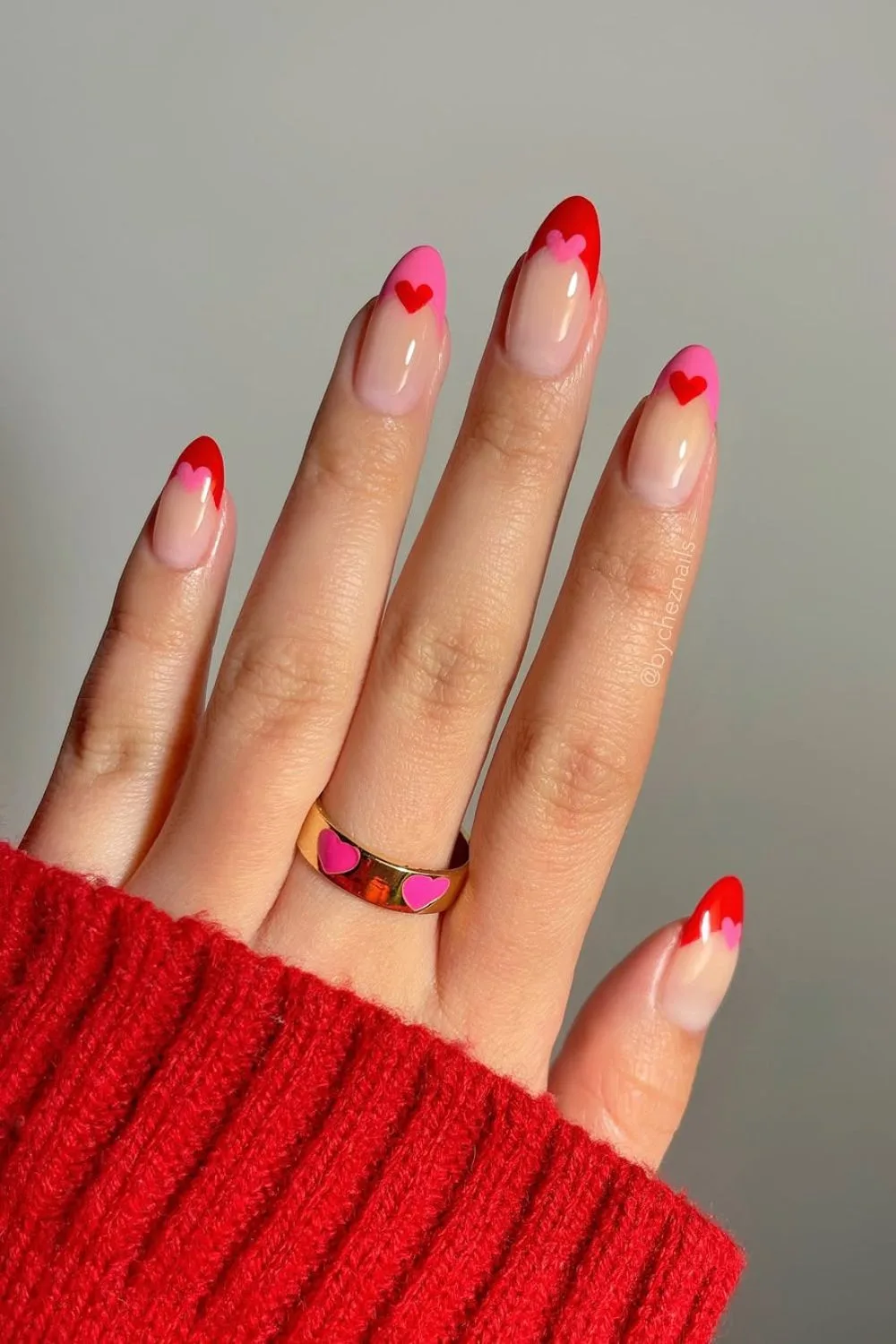 Red and pink French tip nails with heart accents