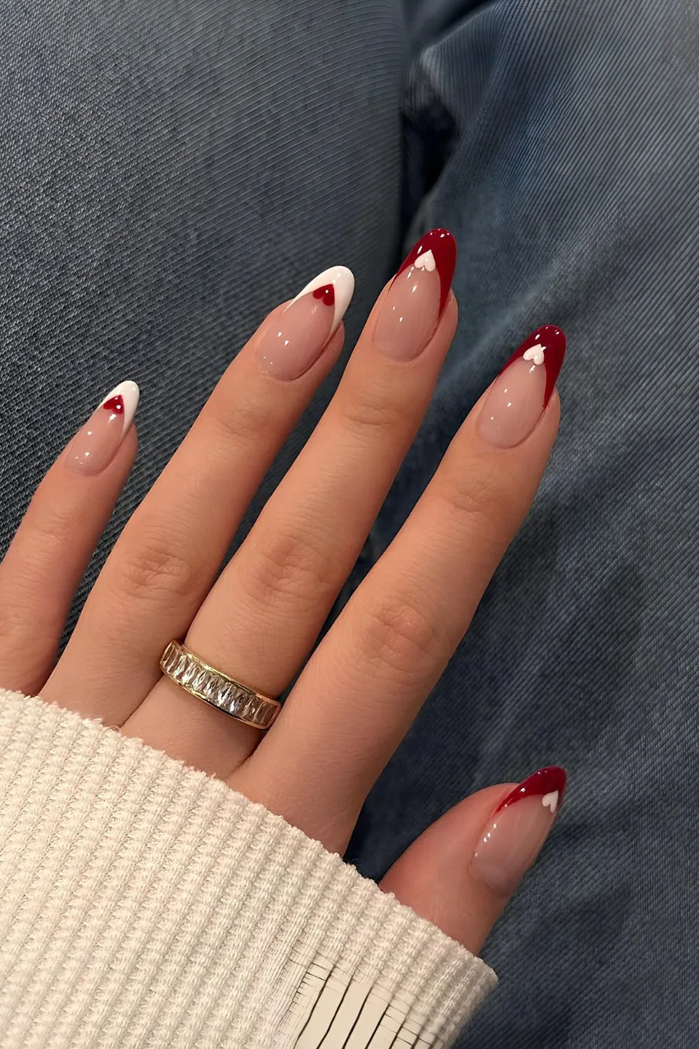 Red and white French nails with heart accents on tips