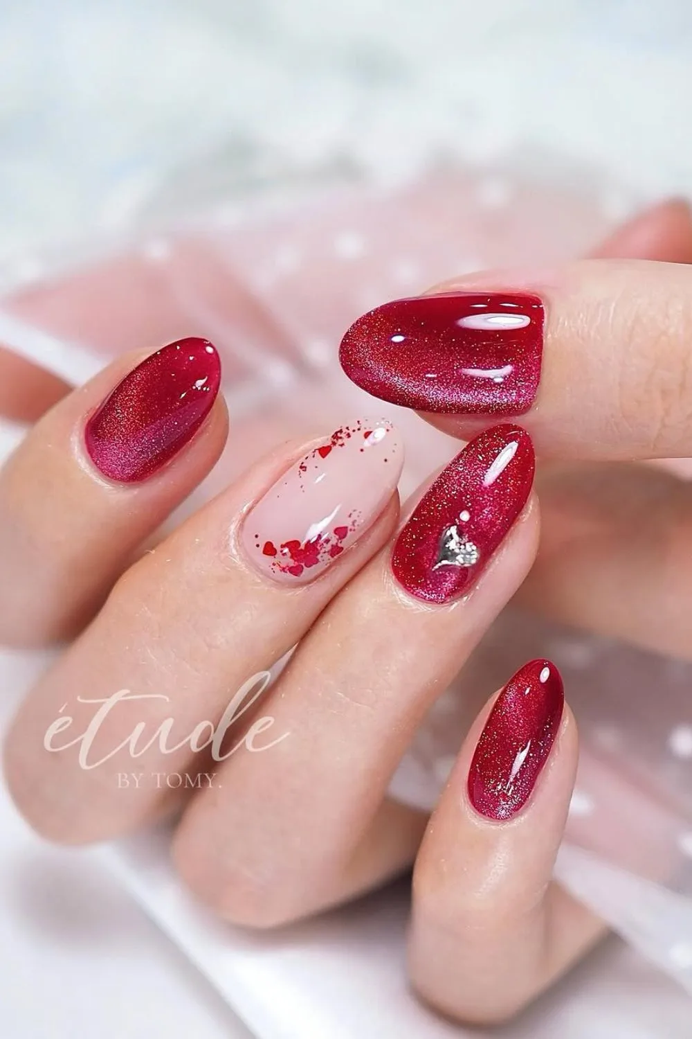 Red cat-eye nails with silver heart accent