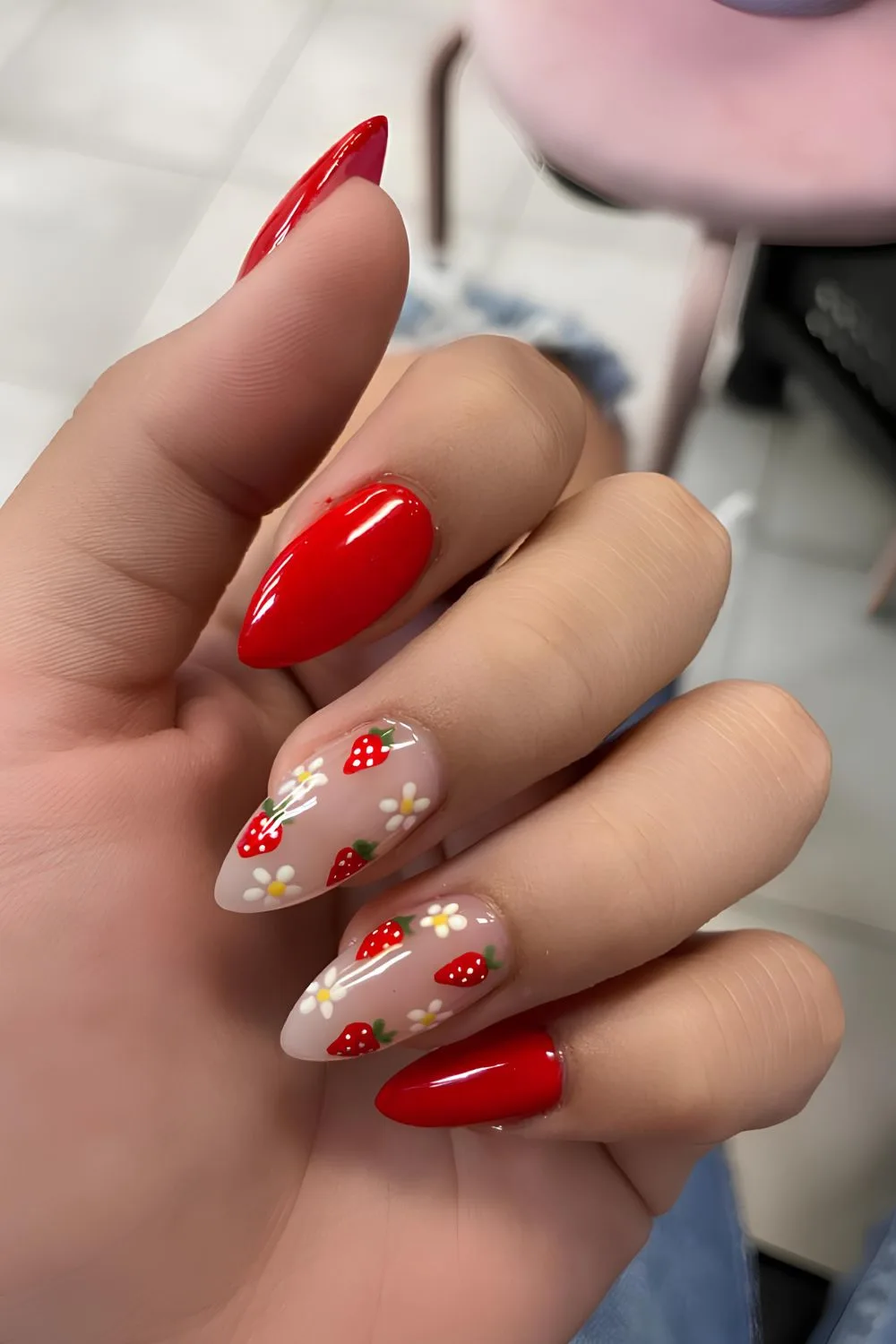 Red manicure with strawberry and daisy art